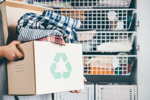 Caja de reciclaje llena de ropa.
