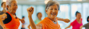 A happy senior woman doing Zumba in a gym class.